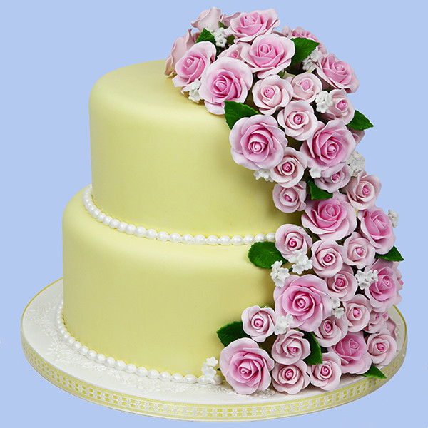 Image of yellow cake with pink roses and pearl trim.